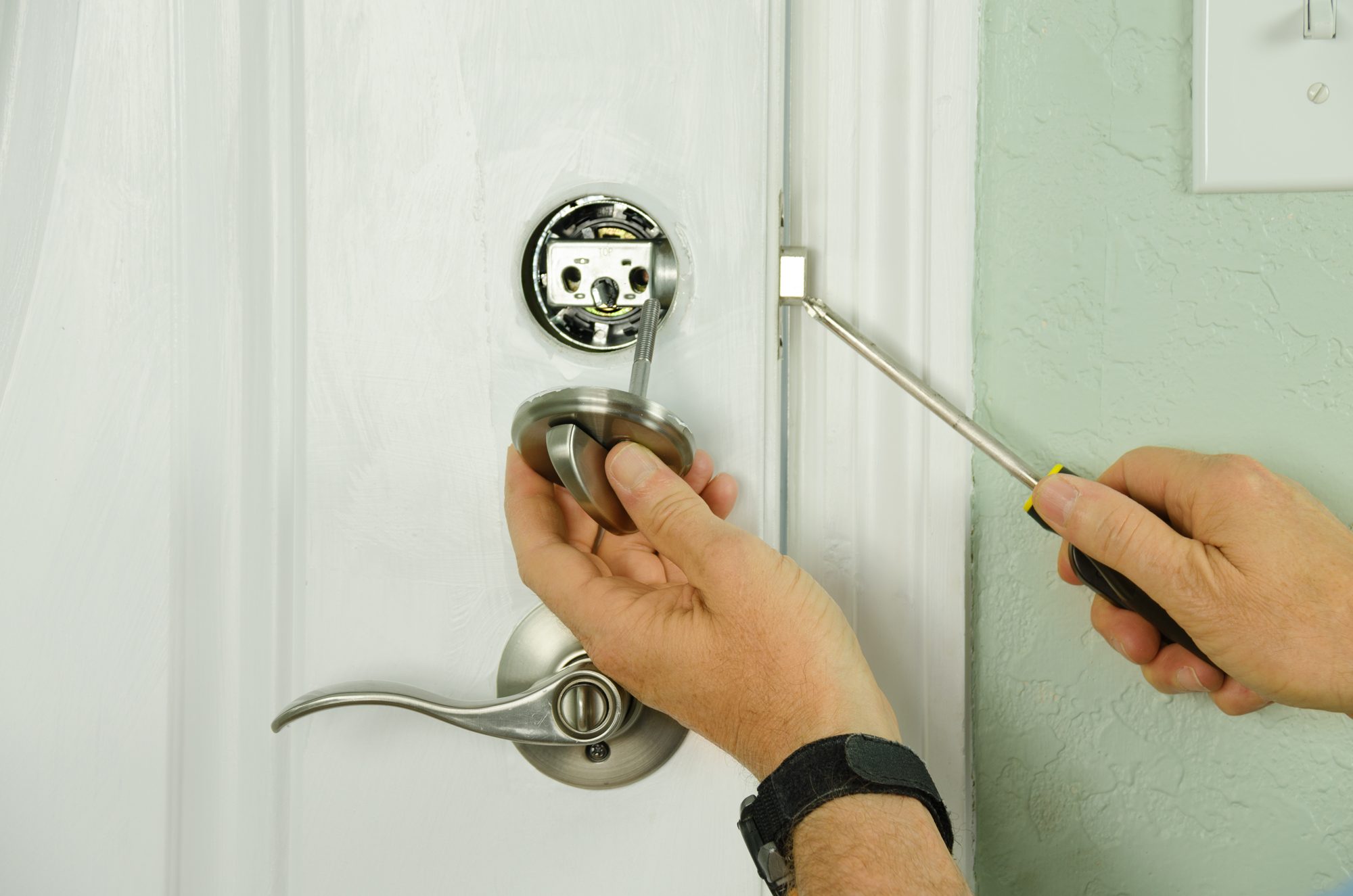 Technician installing a deadbolt on a front door